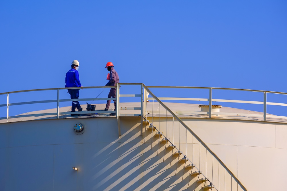 engineer-and-worker-working-on-top-of-fuel-storage-2026-03-24-06-23-26-utc